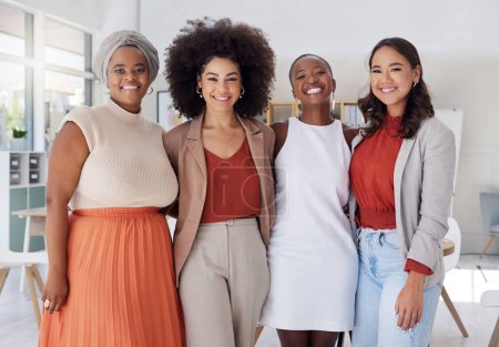 Photo for Portrait of a diverse group of smiling ethnic business women standing together in the office. Ambitious happy confident professional team of colleagues embracing while feeling supported and empowered. - Royalty Free Image