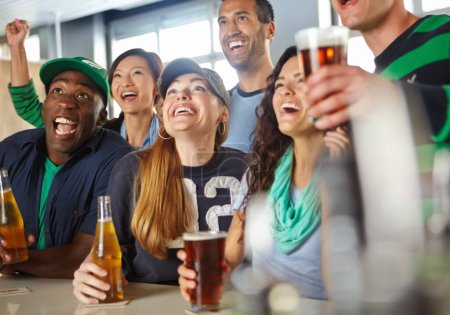Photo for Come on. A group of friends cheering on their favourite sports team at the bar - Royalty Free Image