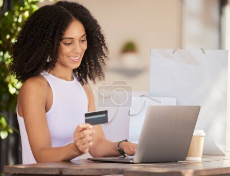 Schwarze Frau, Laptop und Kreditkarte für E-Commerce, Online-Shopping und das Bezahlen mit Fintech-Software in einem Café mit Wifi-Verbindung. Kundin in Paris beim Internet-Banking.