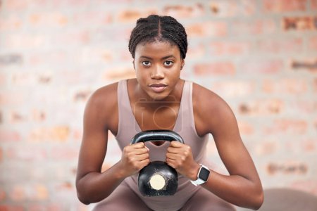 Foto de Mujer negra, cara y kettlebell en el entrenamiento de gimnasio, entrenamiento o ejercicio para el crecimiento muscular del cuerpo, el bienestar cardiológico o la atención médica. Retrato, fitness deportivo y levantamiento de pesas de entrenadores personales en Jamaica. - Imagen libre de derechos