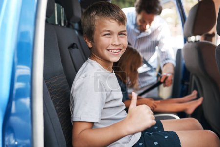 Photo for Im ready to go. Cropped portrait of a young boy sitting in the car and showing a thumbs up before roadtripping with his family - Royalty Free Image