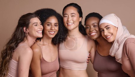 Foto de Retrato facial, belleza y diversidad de mujeres en estudio aisladas sobre un fondo marrón. Maquillaje, cosmética y grupo de diferentes modelos femeninos posando juntos para el amor propio, inclusión y empoderamiento - Imagen libre de derechos