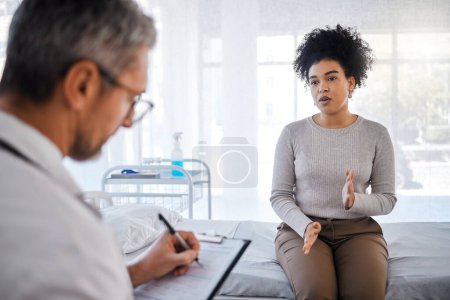 Healthcare, consulting and insurance with a black woman patient sitting in a hospital with her doctor. Medical, consultant and insurance with a female talking to a medicine professional for diagnosis.