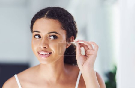 Photo for You have to take care of those hard to reach places. an attractive young woman cleaning her ears with a cotton bud - Royalty Free Image