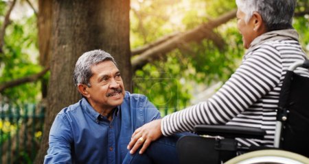 Photo for Hes always making sure Im comfortable. a happy wheelchair bound senior woman spending the day with her husband at the park - Royalty Free Image