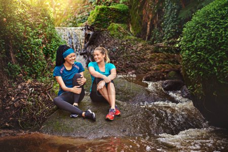 Photo for Life is better with a good friend. two sporty young women taking a break while out exercising in nature - Royalty Free Image
