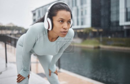 Photo for Headphones, fitness and runner woman on a urban street with motivation, music and exercise. City run, sport and marathon training workout of a black woman athlete listening to web radio for sports. - Royalty Free Image