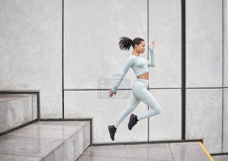 Photo for Running stairs and jump of a black woman doing training, sport and exercise with energy. Jumping, runner and morning fitness of woman doing sports, workout and cardio by steps for health and wellness. - Royalty Free Image