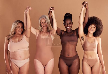 Photo for Beauty, diversity and natural with woman friends in studio on a beige background with their hands raised in celebration. Wellness, underwear and real with a model female group standing together. - Royalty Free Image