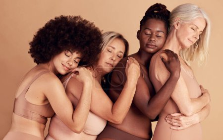 Photo for Beauty, diversity and group in lingerie hug for skin color underwear campaign with comfortable body pose. Young, senior and interracial body positive model women on beige studio background - Royalty Free Image