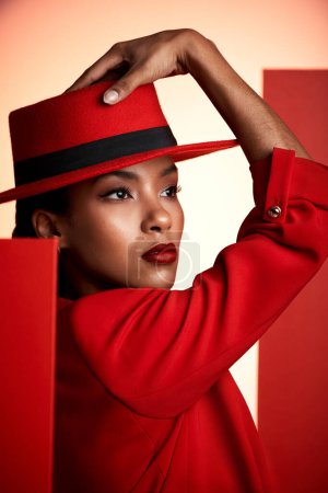 Beauty, fashion and aesthetic woman in red suit for cosmetics, makeup and designer brand clothes advertising while thinking about color. Face of strong 90s retro model in studio for empowerment.