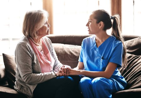Foto de Tienen una conexión especial. una enfermera sosteniendo a una mujer mayor con las manos cómodas - Imagen libre de derechos