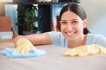 Photo for Cleaning, woman or portrait happy cleaner with cloth and gloves for dusty, messy or dirty bacteria on wooden table. Smile, cleaning service or girl wipes germs furniture surface in home office room. - Royalty Free Image