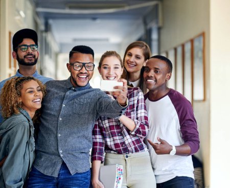 Téléchargez les photos : Il est toujours temps pour un selfie. un groupe de jeunes étudiants universitaires prenant des selfies sur le campus - en image libre de droit