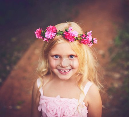 Téléchargez les photos : Le bonheur de l'enfance. une petite fille heureuse regardant la caméra et souriant tout en se tenant au milieu d'un chemin de terre - en image libre de droit