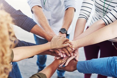 Photo for Were stronger when we unite together. Closeup shot of a group of people joining their hands together in a huddle - Royalty Free Image