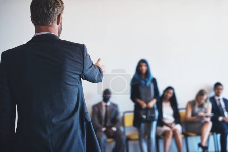 Photo for You may step forward. a group of confident businesspeople waiting in line for their interviews inside of a office during the day - Royalty Free Image