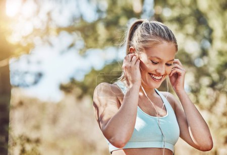 When that perfect running song plays. a young woman listening to music outdoors