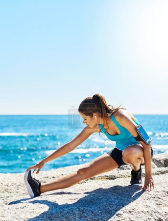 Photo for Getting ready for action. a young woman stretching before her run - Royalty Free Image