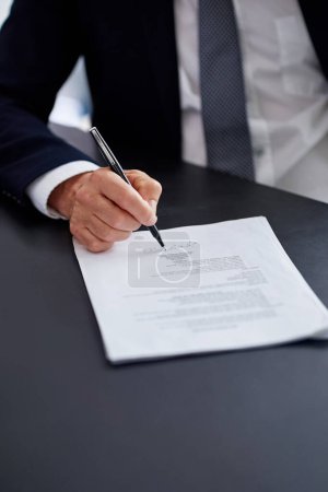 Photo for Making mergers happen. Closeup shot of a businessman signing a contract while sitting at a desk in an office - Royalty Free Image