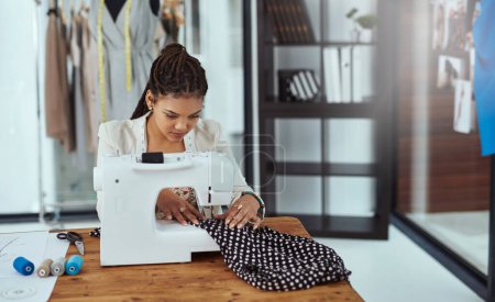 Photo for The final stitch. a young fashion designer using a sewing machine in her workshop - Royalty Free Image