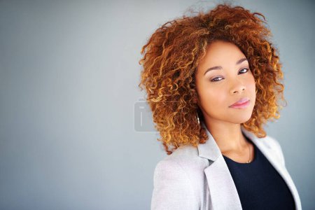 Vertrauen in die Unternehmenswelt. Studioporträt einer jungen Geschäftsfrau vor grauem Hintergrund