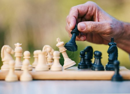 Photo for Chess, play or hand with a king on a board game with a winning strategy in a tournament outdoors in nature. Checkmate, mindset or smart man playing in a sports contest or problem solving challenge. - Royalty Free Image