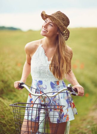 Téléchargez les photos : Rien ne se compare aux plaisirs simples d'une balade à vélo. une jeune femme à vélo à travers la campagne - en image libre de droit