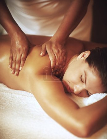Foto de Es hora de mimar. una joven disfrutando de un masaje de espalda - Imagen libre de derechos