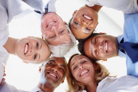 Photo for Teamwork. Low angle view of multi ethnic business group in huddle at office - Royalty Free Image