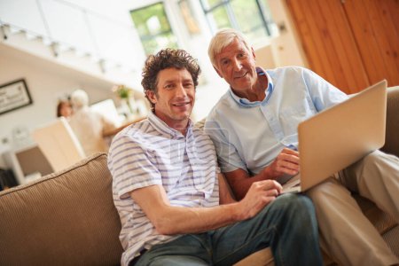 Téléchargez les photos : On se retrouve pour un moment père-fils. un homme et son père assis avec un ordinateur portable à l'intérieur - en image libre de droit