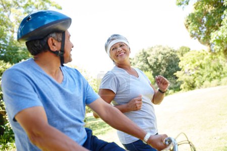 Photo for Together forever in love and fitness. a happy senior couple going for a bike ride and a jog together outdoors - Royalty Free Image
