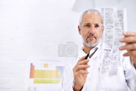 Photo for Let me see...a male scientist analyzing the results of a DNA test - Royalty Free Image