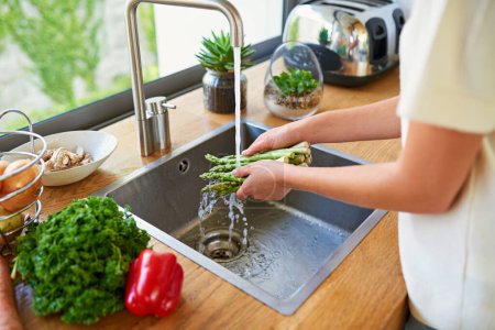 Photo for Always clean your veggies. a woman washing vegetables in a kitchen sink - Royalty Free Image