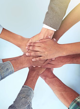 Photo for All for one. High angle shot of a group of coworkers with their hands in a huddle - Royalty Free Image