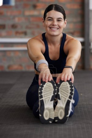 Foto de Fitness, woman stretching in gym for workout, body training and start exercise with warm up portrait. Female smile, sports motivation and wellness, strong muscle with pilates and sneakers for workout. - Imagen libre de derechos