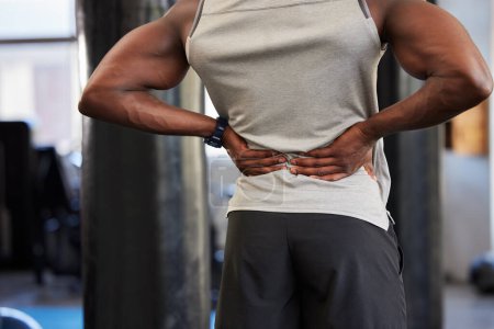 Foto de Black man, fitness or back pain in gym workout, exercise or training and body anatomy crisis, muscle burnout or spinal tension. Sports athlete, personal trainer or coach with injury or health problem. - Imagen libre de derechos