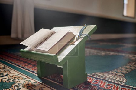 Téléchargez les photos : Quran, prayer beads and mosque with an open book and a rosary in an empty holy room or temple ready for praying. Islamic misbaha, tasbih or sibha and scripture in a muslim place of worship for eid. - en image libre de droit