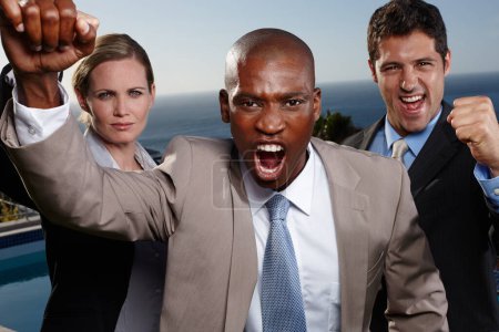 Photo for Our success is unrivalled. A portrait of three enthusiastic bussinesspeople raising their fists in accomplishment - Royalty Free Image
