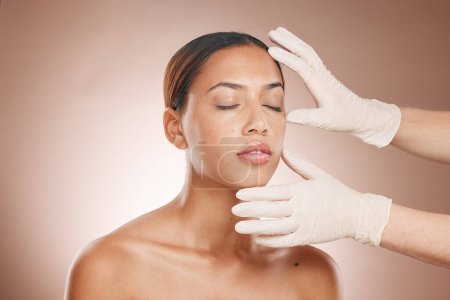 Photo for Plastic surgery, woman and doctor hands check face for botox, beauty implant and makeup cosmetics. Skincare consultation, facial and gloves for aesthetics, filler and body change on studio background. - Royalty Free Image