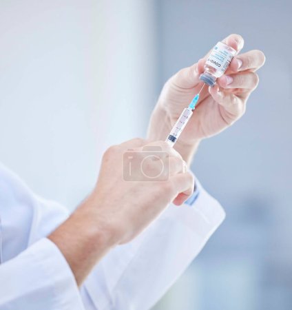 Foto de Hands, covid and doctor with vaccine syringe for healthcare, wellness and virus immunity. Corona, injection and medical professional holding needle for vaccination and covid 19 prevention in hospital. - Imagen libre de derechos
