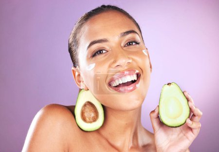 Téléchargez les photos : Avocado, cream and skincare woman in studio portrait for face glow, healthy shine and cosmetics advertising mockup. Black woman model with nutrition, vegan fruit for dermatology product and self love. - en image libre de droit