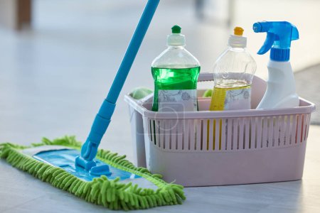 Photo for Cleaning, product and basket with mop, bottle and spray for cleaning services, wellness or chemical disinfection. Closeup of spring cleaning supplies, container and tools to dust house, floor or home. - Royalty Free Image