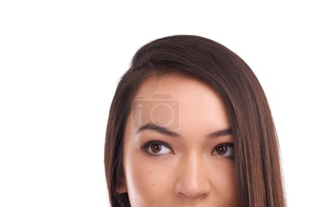Photo for Somethings has got her interest...Studio headshot of a young woman looking up at copyspace - Royalty Free Image