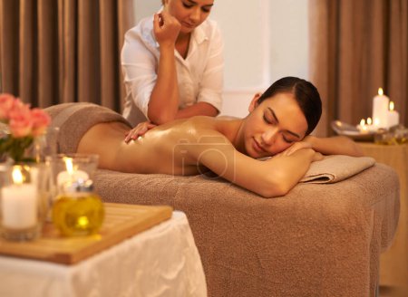 Téléchargez les photos : Letting her stress melt away. A beautiful young woman enjoying a massage at the spa - en image libre de droit