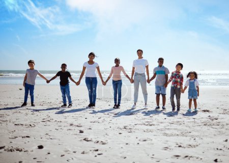 Foto de Beach, holding hands and lesbian women with children for support, holiday diversity and big family love in Indonesia. Trust, hope and portrait of parents with kids for a travel vacation at the sea. - Imagen libre de derechos