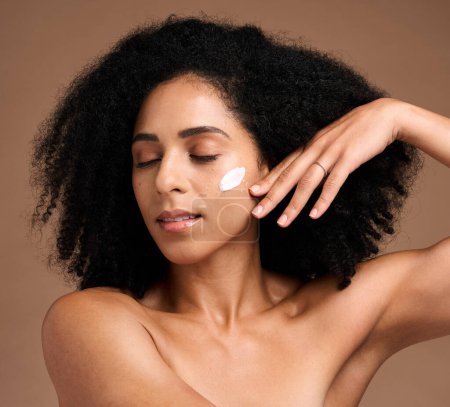Téléchargez les photos : Skincare, black woman and cream for face detox, organic facial and on brown studio background. African American female, girl and lotion for wellness, smooth and clear skin for beauty and cosmetics. - en image libre de droit