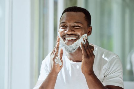 Photo for Shaving, cream and black man grooming face for clean look, hygiene care and beauty morning routine in the bathroom. Skincare, happy and African person ready to shave beard and facial hair with foam. - Royalty Free Image