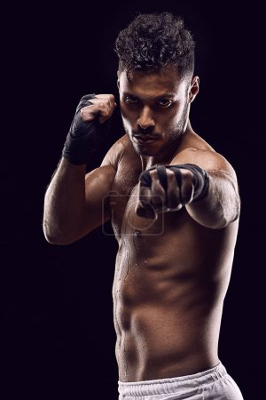 Photo for If he cant reach you he cant hit you. Studio shot of a young boxer isolated on black - Royalty Free Image