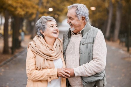 Téléchargez les photos : Senior couple, love and hug while walking outdoor for exercise, happiness and care at a park in nature for wellness. Old man and woman together in a healthy marriage during retirement with freedom. - en image libre de droit